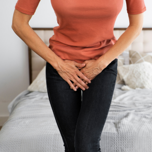 woman with her hands covering her crotch area.